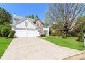Inviting two-story home featuring a long driveway and lush green lawn at 2168 Sugar Maple Nw Cv, Acworth, GA 30101