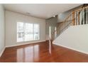 Open living room featuring a staircase, large window, and gleaming hardwood floors at 2168 Sugar Maple Nw Cv, Acworth, GA 30101