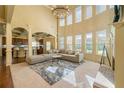 Bright living room featuring two-story windows, large neutral couch, and modern light fixture at 2369 Apalachee Crucis Ln, Dacula, GA 30019