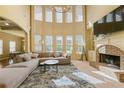 Spacious living room with floor-to-ceiling windows, brick fireplace, and comfortable seating at 2369 Apalachee Crucis Ln, Dacula, GA 30019
