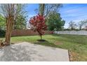 Concrete patio area with a tree in the yard and a wood fence surrounding the property at 2500 Grand Manor Ct, Marietta, GA 30068