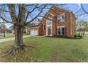 Attractive two-story home with a brick facade, mature trees, and a green lawn at 2500 Grand Manor Ct, Marietta, GA 30068