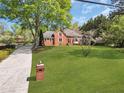 Beautiful brick home with a well-maintained lawn and mature trees, offering a picturesque setting at 3175 Old Jonesboro Rd, Fairburn, GA 30213