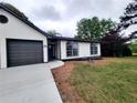 Home featuring gray two-car garage, arched windows, and manicured landscaping at 2831 Skye Ter, Duluth, GA 30096