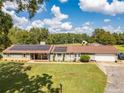 Well-maintained home with solar panels, a manicured lawn, and stone accents, offering eco-friendly living and curb appeal at 3557 Bill Gardner Pkwy, Locust Grove, GA 30248