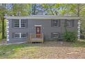 Charming two-story home with a brick facade and a cozy front porch, set amidst lush greenery and mature trees at 149 Roy Huie Rd, Riverdale, GA 30274