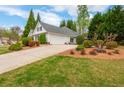 Home exterior showcasing a well-maintained lawn, a driveway, and mature landscaping at 133 Newcastle Walk, Woodstock, GA 30188