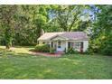 Inviting single-story home with a cozy front yard and a traditional design nestled in a verdant, tree-lined setting at 3750 Mckown Rd, Douglasville, GA 30134