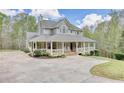 Charming two-story home with a sprawling front porch and a well-manicured lawn at 7746 Tyree Rd, Winston, GA 30187