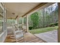 Inviting front porch featuring rocking chairs and scenic views of lush landscaping at 7746 Tyree Rd, Winston, GA 30187