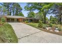 Inviting brick home with an extended driveway and charming landscaping, offering great curb appeal at 2419 Little John Se Trl, Marietta, GA 30067