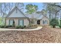 Beautiful single-story home with brick exterior, complementing green shutters, and a meticulously landscaped front yard at 3230 Riverhill Ct, Cumming, GA 30041