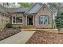 Close up of the front of a beautiful brick house with stone steps leading to a covered front door at 3230 Riverhill Ct, Cumming, GA 30041