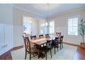 Dining room with modern lighting, chair rail, and hardwood floors, leading to other rooms at 4495 Alister Park Dr, Cumming, GA 30040