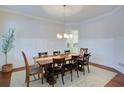 Well-lit dining room with seating for eight, hardwood floors, wainscoting and decorative chandelier at 4495 Alister Park Dr, Cumming, GA 30040