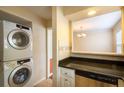 Bright laundry area with stacked washer/dryer and a granite countertop at 177 Nw Amherst Pl, Atlanta, GA 30327