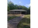 A single story home with a white picket fence, attached carport and long driveway at 2598 Miriam Ln, Decatur, GA 30032