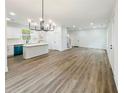 Spacious living room and kitchen with an elegant chandelier and wood-look flooring at 5215 Virginia Ave, Cumming, GA 30041
