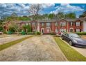 Charming brick townhomes featuring landscaped front yards and a paved parking space at 5587 Strathmoor Manor Cir, Lithonia, GA 30058