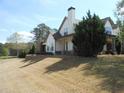 Beautiful two-story home with an open lawn, stone accents, and manicured landscaping at 325 Brook Hollow Ln, Loganville, GA 30052