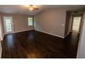 Spacious living room with ceiling fan, hardwood floors, and natural light at 945 Navajo Trl, Covington, GA 30016