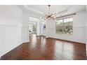 Formal dining room featuring hardwood floors, decorative chandelier, and large windows, perfect for entertaining at 241 Haney Rd, Woodstock, GA 30188