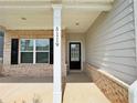 Inviting front porch with brick accents, white columns, and clear house number display at 5119 Aylesbury Ct, Hoschton, GA 30548