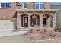 Inviting front porch with stone arches and walkway leading to the front door at 7130 Rocking Horse Ln, Cumming, GA 30040