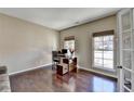 Bright office space with hardwood floors, large windows, and a modern desk at 7130 Rocking Horse Ln, Cumming, GA 30040