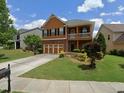 Inviting two-story home featuring a second-story balcony, a two-car garage and a well-maintained front lawn at 1668 Scenic Pines Dr, Lawrenceville, GA 30044