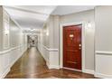 Long hallway with paneled walls and wood floors leading to the unit's front door at 200 River Vista Dr # 713, Atlanta, GA 30339