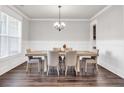 Bright dining room with a wooden table, six chairs, and a modern chandelier at 1501 Branthaven Ln, Auburn, GA 30011