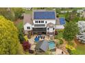 Aerial view of backyard with pool, hot tub, outdoor kitchen, screened porch, lush landscaping, and solar panels at 332 Chaffin Rd, Roswell, GA 30075