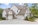 Charming two-story home showcasing a three-car garage and manicured landscaping at 332 Chaffin Rd, Roswell, GA 30075