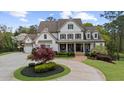 Charming home with manicured landscaping, a circular driveway, and a welcoming front porch at 332 Chaffin Rd, Roswell, GA 30075