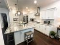 Bright, open kitchen with white cabinetry, stainless appliances, granite counters, and a large island at 11212 Snowy Owl Ln, Alpharetta, GA 30022