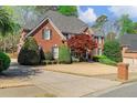Two-story brick house featuring well-maintained landscaping, large driveway, and attached garage at 3605 Grey Abbey Dr, Alpharetta, GA 30022