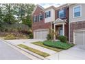 A charming two-story brick townhome featuring an attached garage and manicured landscaping at 4236 Silver Spruce Ln, Smyrna, GA 30080