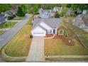 Aerial view of a lovely single-Gathering home showcasing its manicured lawn, mature trees, and proximity to a quiet residential street at 1193 Colony Creek Ct, Lawrenceville, GA 30043