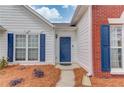 Close-up of a home's inviting blue front door framed by brick, white siding, and neatly landscaped flower beds at 1193 Colony Creek Ct, Lawrenceville, GA 30043