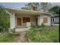 Charming bungalow-style home with a covered porch and overgrown yard needs renovation and TLC at 1366 Sylvan Sw Rd, Atlanta, GA 30310