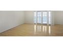 Bright, empty room with light hardwood floors and French doors that open to a balcony at 1445 Monroe Ne Dr # C6, Atlanta, GA 30324