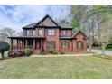 Charming brick home with a well-maintained lawn, covered porch, and shuttered windows at 220 Carriage Station Dr, Lawrenceville, GA 30046