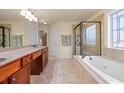 Bright bathroom featuring double sinks, a soaking tub, and a glass-enclosed shower at 2694 Dawning Day Dr, Dacula, GA 30019