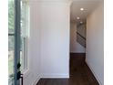 Inviting hallway with dark hardwood floors, natural light, and staircase leading to the upper level at 702 Dodd Ln # 159, Buford, GA 30518