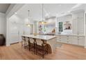 Bright, open kitchen features a large center island with counter seating and modern pendant lighting at 100 Maison Ct, Roswell, GA 30076