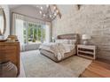 Charming main bedroom with a decorative stone wall, a large window and hardwood flooring at 100 Maison Ct, Roswell, GA 30076