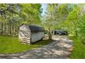 View of storage building with driveway through wooded lot at 3541 Hutcheson Ferry Rd, Whitesburg, GA 30185