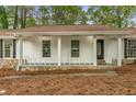 Charming front porch with stone base, white railings, and decorative front door at 2694 Hickory Valley Dr, Snellville, GA 30078
