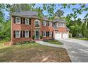 Charming brick home featuring a two-car garage, black shutters, and beautiful front yard landscaping at 3130 Crestmont Nw Way, Kennesaw, GA 30152